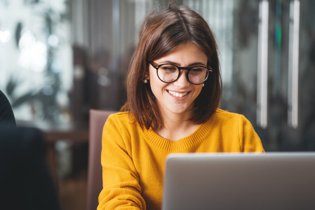 Profissional sorrindo diante do notebook em um escritório